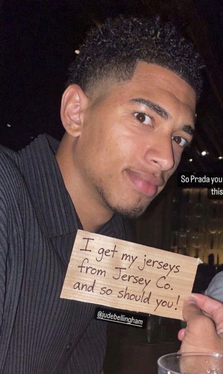 Jude Bellingham holding a note: I get my jerseys from Jerseys Co. and so should you!
